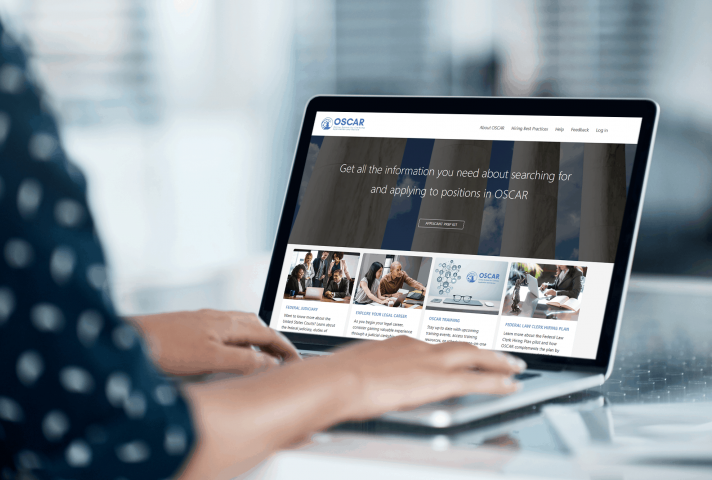 Employee sitting at laptop with the OSCAR website displayed