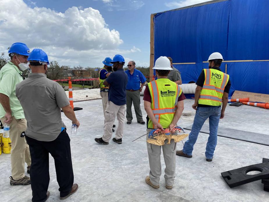 Chief Judge S. Maurice “Maury” Hicks (center, in blue shirt) inspects the roof of the Lake Charles courthouse. 